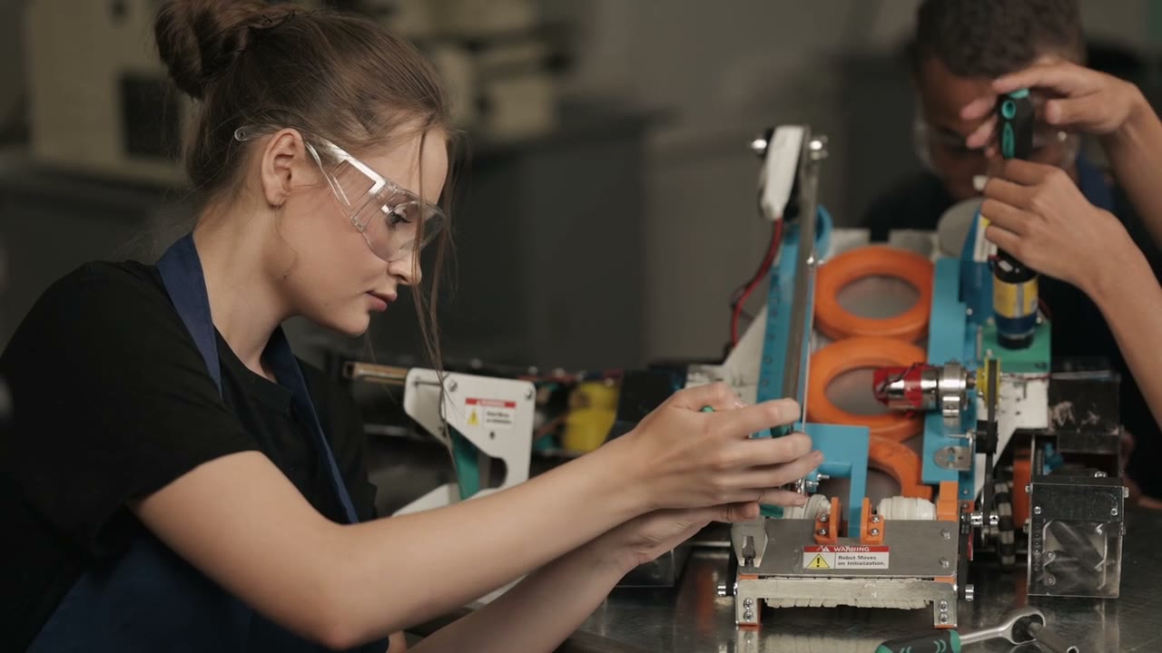 Two engineers assembling a robot at a workbench